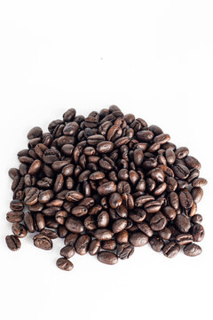 Coffee Beans on white background. Coffee grounds. Freshly roasted coffee beans. Image of a drink made from granules, derived from coffee plant. Copy space for text.
