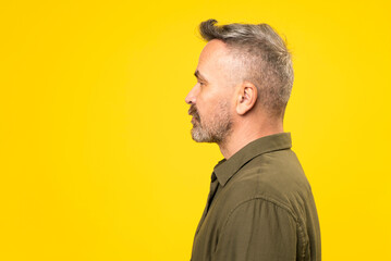 Side view of mature happy bristle man. Profile portrait of middle-age man dressed in green shirt...
