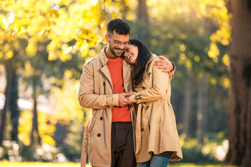 Fototapeta premium Couple in love walking on autumn park, enjoying a beautiful autumn day.