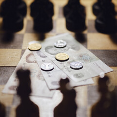 Chinese yuan money on the background of a chess board. Banknotes and coins of yuan from China on...