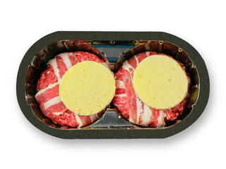 Two premium beef burgers wrapped in rashers or bacon and butter and cheese on top in a black plastic tray on white background. Luxury product for barbecue or grill.