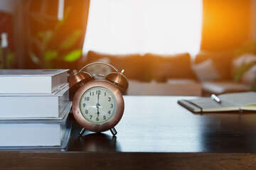 desk clock and books on wooden table
