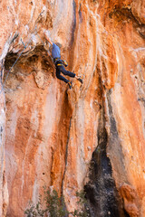 Extreme sport, strong man, rock climber climbs a difficult route.