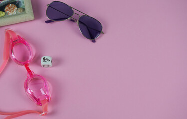 Fototapeta premium Sunglasses protective goggles and goggles for swimming on a pink background. Concept - planning a trip.
