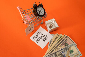 basket clock gifts with discounts and dollars lie isolated on an orange background.