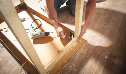 Caucasian carpenter repairing broken table.