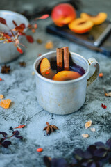 Metal rustic mug with homemade non-alcoholic hot drink from seasonal berries and fruits on the table. Close up still life.