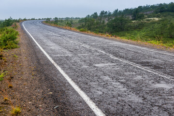 Asphalt road in polar tundra landscape. Far North of Russia