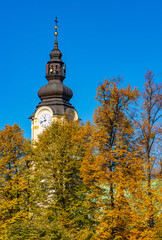 Clock tower of St. Matthias church, kosciol sw. Macieja, over autumn colors in historic old town...