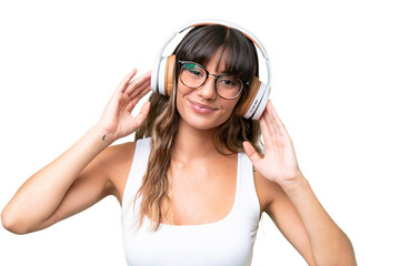 Young caucasian woman over isolated background listening music