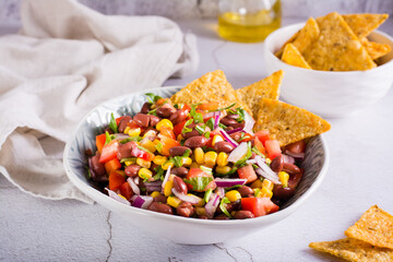 Mexican vegetable salad cowboy caviar and nachos in a bowl on the table