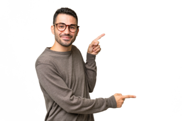 Young handsome caucasian man over isolated background pointing finger to the side and presenting a product