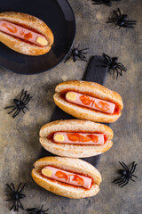 Hot dogs from sausage and cheese in ketchup in buns on slate. Halloween recipe. Top and vertical