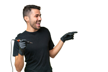 Tattoo artist caucasian man over isolated background pointing finger to the side and presenting a product