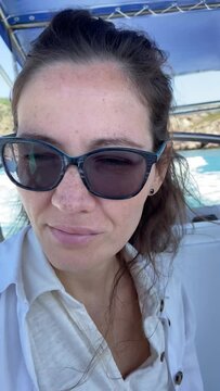 Vertical in 60 fps Girl with glasses portrait close-up during a boat trip