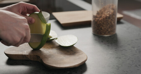 man cut green mango on olive wood board