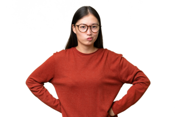 Young Asian woman over isolated background having doubts while looking up