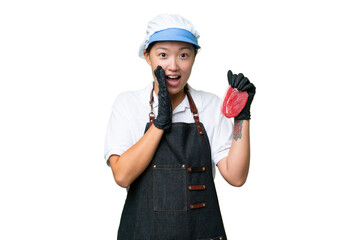 Young caucasian woman wearing an apron and serving fresh cut meat over isolated background with surprise and shocked facial expression
