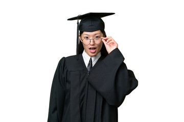 Young university graduate Asian woman over isolated background with glasses and surprised