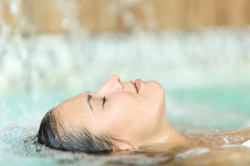 Woman floating and relaxing in a spa pool