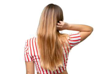 Young beautiful woman over isolated background in back position and thinking