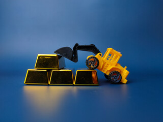 Excavator and gold bar on blue background. Business concept.