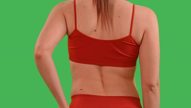 woman dressed red top and sport leggings touch back pain after workout health care concept Isolated on Green Screen studio