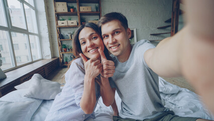 Point of view shot of happy couple famous bloggers recording video for their followers at home....