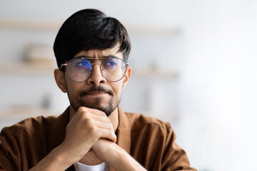 Sceptical middle eastern young man with glasses, copy space - obrazy, fototapety, plakaty