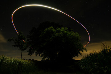 Night sky with tree and cirvle of drone light