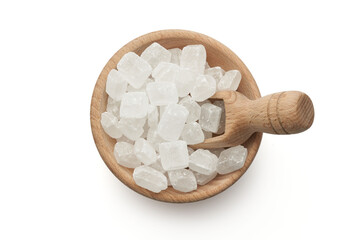 Cukier biały lodowy w dużych kostkach w drewnianej miseczce z łopatką na białym tle