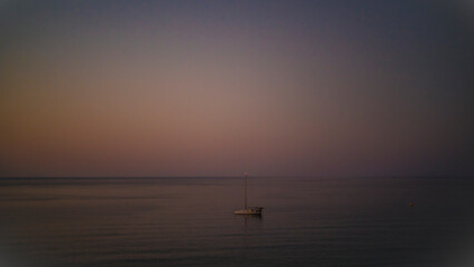 Sailboat on calm sea at dusk