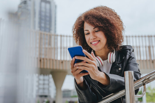 Smiling young woman surfing the net on smart phone