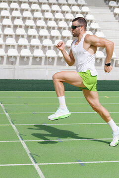 Determined athlete practicing running at sports track