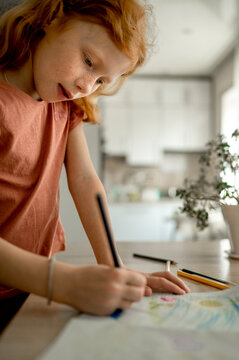 Girl drawing with color pencil at home