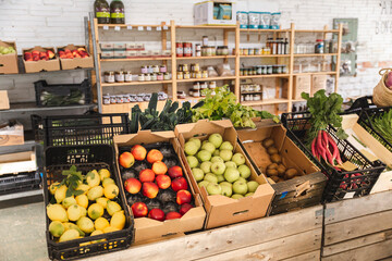 Fresh fruits and vegetables arranged in crates at greengrocer shop