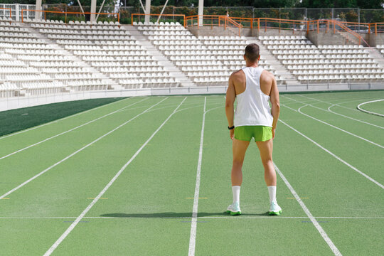 Athlete standing on running track on sunny day