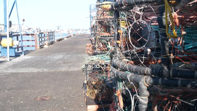 Traps, ropes and cages on pier, commercial dock, fishing industry, Monterey California USA. Empty pots, creels for fish seafood catching in port. Many fisherman's nets and baskets in seaport. Fishery.