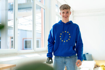 Happy teenage boy with amputated arm wearing European Union symbol hoodie