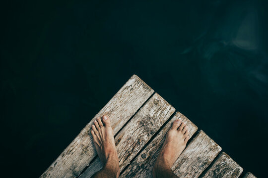 Man standing on wooden jetty over Monticolo Lake