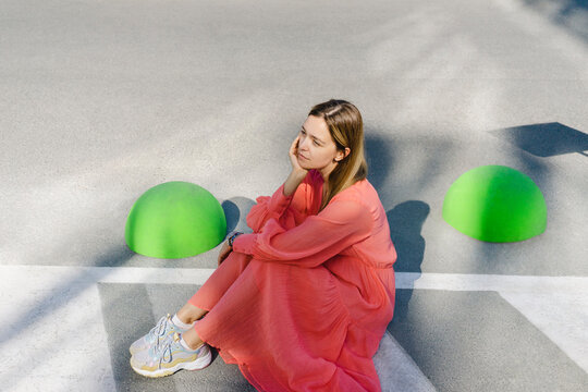 Thoughtful woman sitting on road
