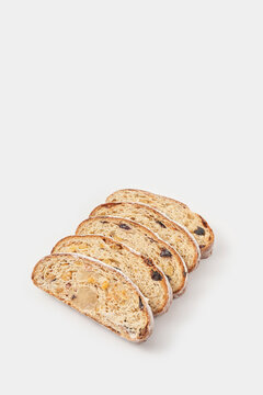 Slices of stollen fruit cake arranged on white background