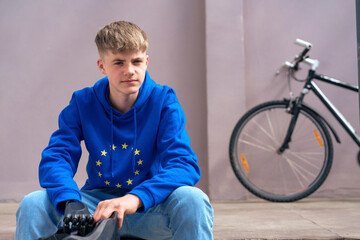 Blond boy with amputated arm sitting in front of bicycle
