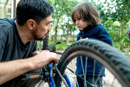 Father Teaching Son Repairing Bicycle