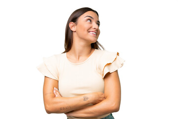 Young caucasian woman isolated on green chroma background looking up while smiling