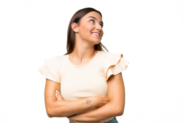 Young caucasian woman isolated on green chroma background looking up while smiling