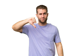 Young handsome caucasian man isolated on green chroma background showing thumb down with negative expression