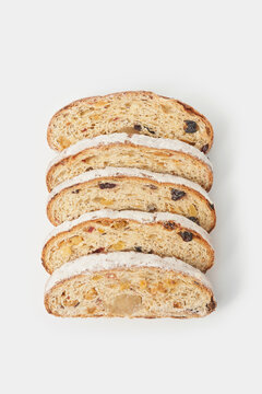 Christmas stollen cakes with icing sugar arranged against white background