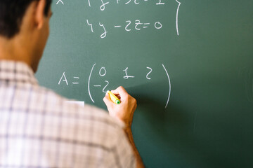 Math teacher solving problems on chalkboard