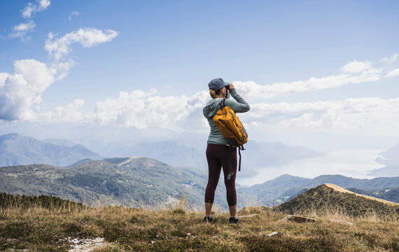 Woman photographing through camera in front of mountains